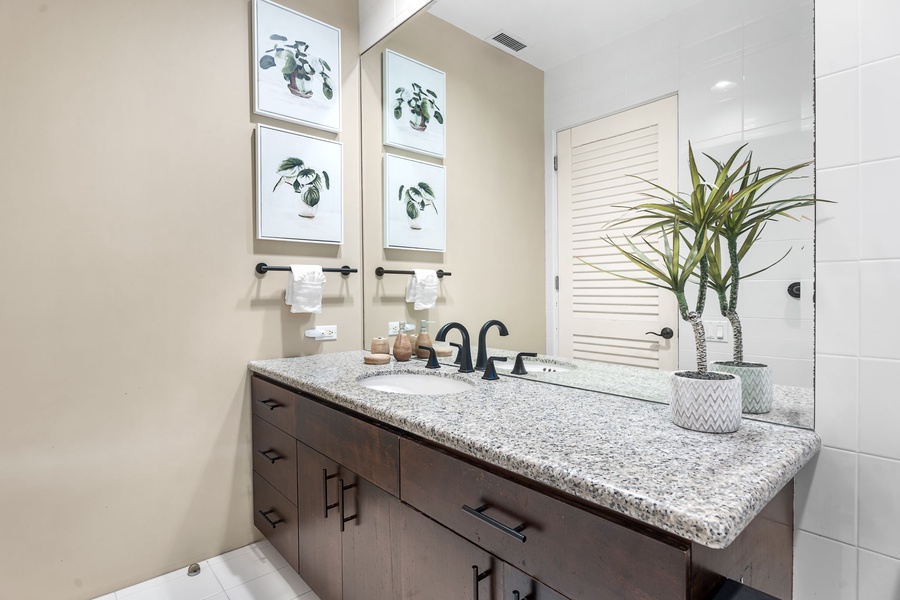 Refresh in your beautifully appointed bathroom featuring granite countertops, elegant botanical artwork, and thoughtful touches.