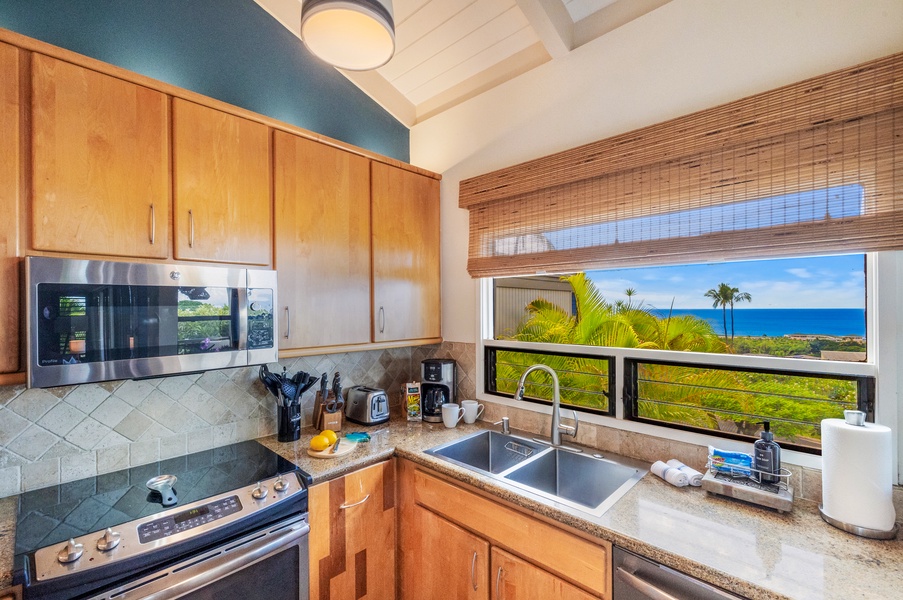 A bright kitchen with modern appliances, ample counter space, and a scenic view of the tropical landscape from the window