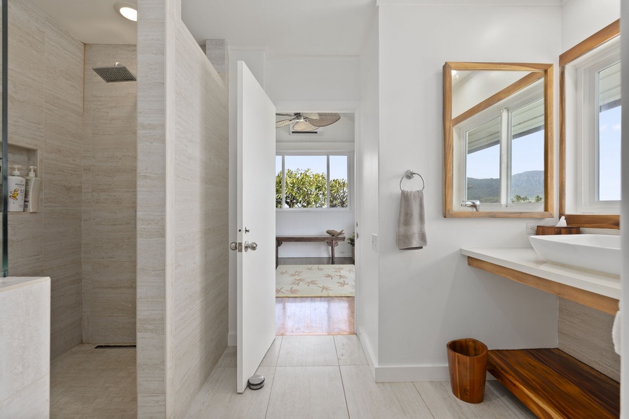Indulge in your shared ensuite retreat with a luxurious rainfall shower and warm wood accents creating the perfect sanctuary.