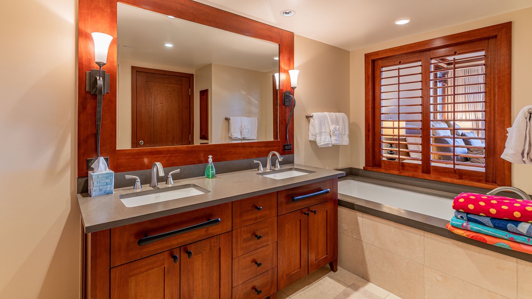 Luxurious guest bath with a soaking tub, dual vanity, and wood accents.