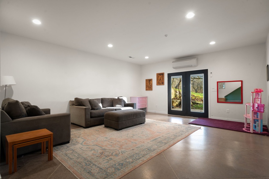 Relax in your spacious media room with plush sectional seating, perfect for movie nights or morning coffee while enjoying garden views.