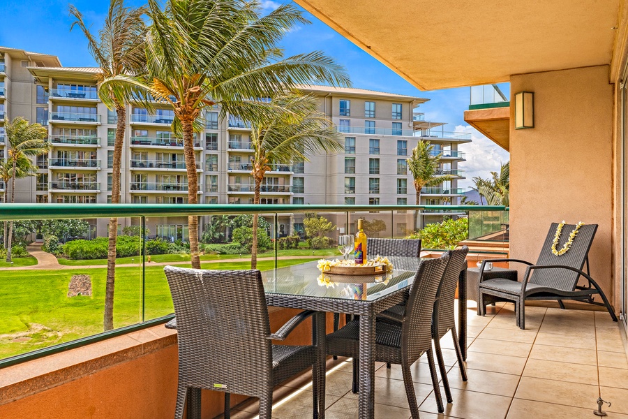 The outdoor lanai offers a spacious dining area with comfortable seating and views of the resort and tropical landscape