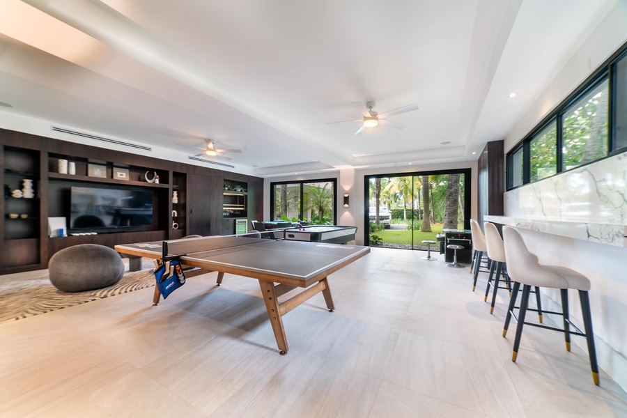 Enjoy friendly competition in this spacious game room equipped with a ping-pong table and bar seating.