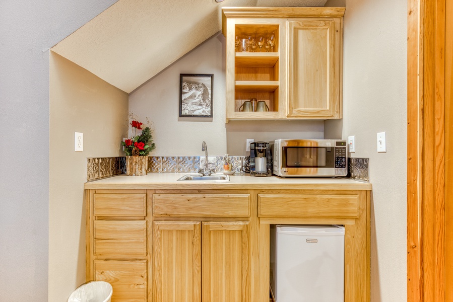 The primary suite kitchenette features a mini fridge, microwave, and sink for quick snacks and drinks.