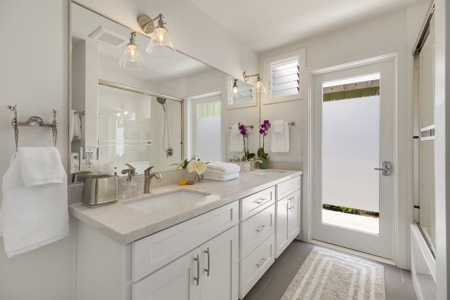 Bright Hallway Bathroom, with full size bathtub and double vanity. Opens to Outdoor Shower.