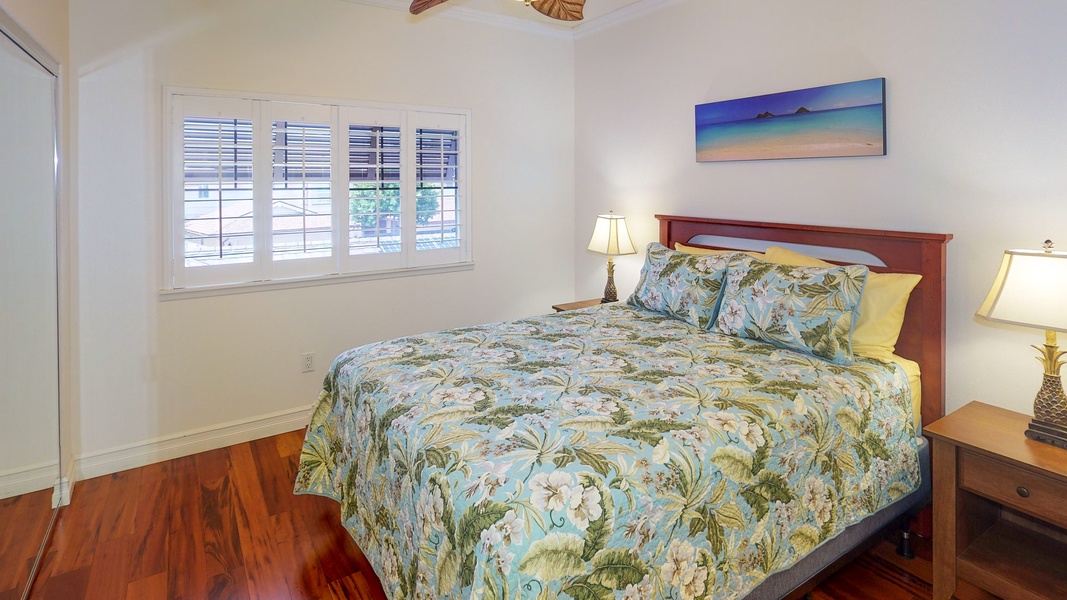 The guest bedroom has queen size bed, ceiling fan and natural light.