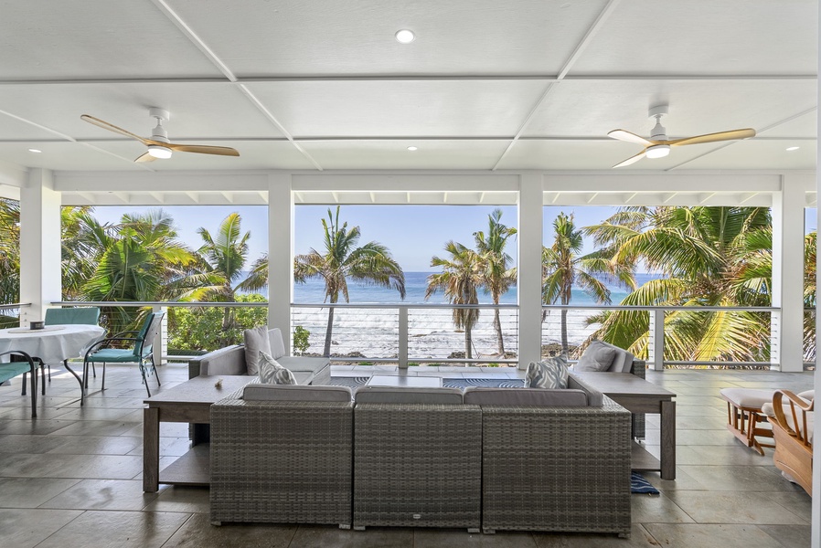 Relax in comfort on the covered lanai, where plush seating and panoramic ocean views create the perfect coastal escape.