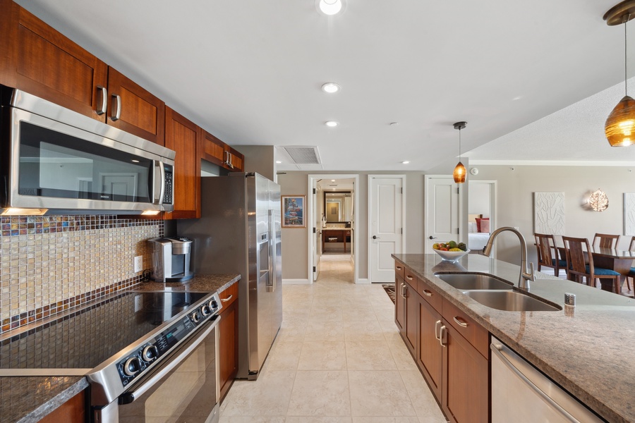 A full-size kitchen at Honua Kai Konea 204 features premium appliances and plenty of space to cook with ease.