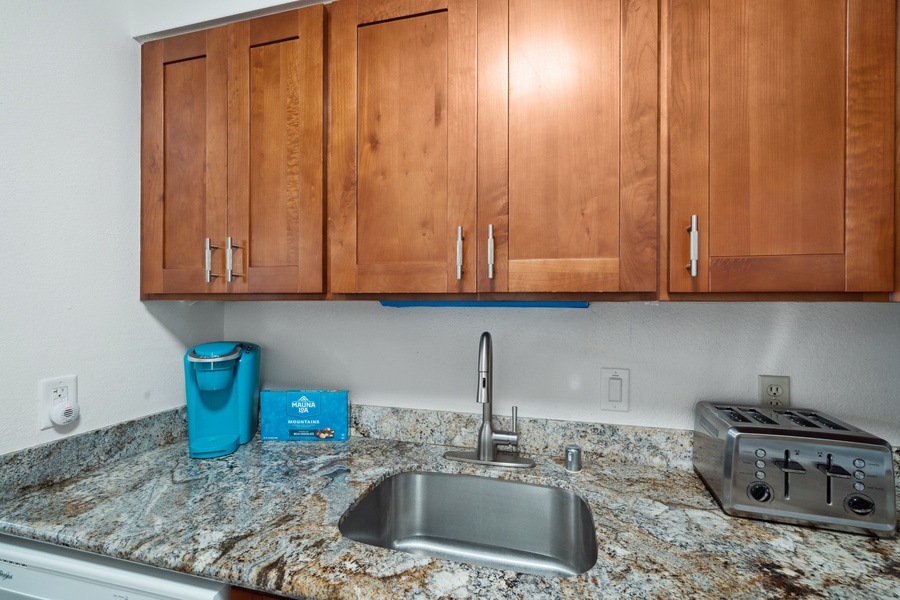 Wood cabinetry and granite counters add warmth and ease to Royal Kahana 308’s kitchen.