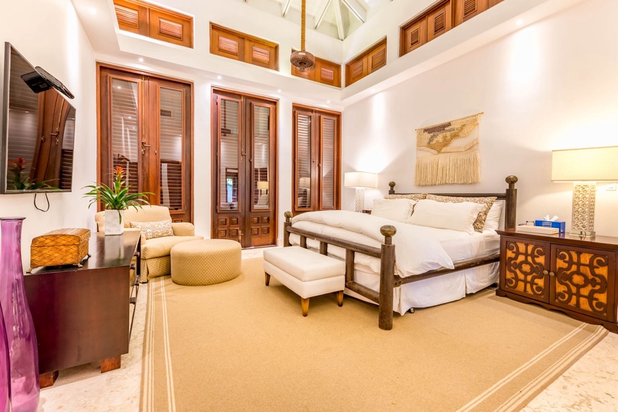 Guest bedroom featuring a plush bed and a reading corner with comfortable seating.