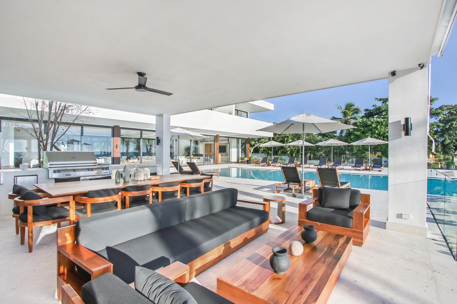 Comfortable outdoor seating area with pool views and a shaded dining space.