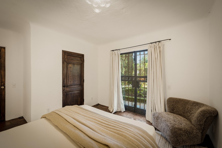 Relax in your serene bedroom with elegant wooden details and French doors opening to a private balcony.