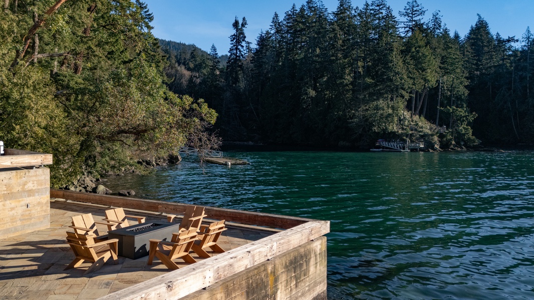 Serene lakefront setting with forested hills and clear blue waters.