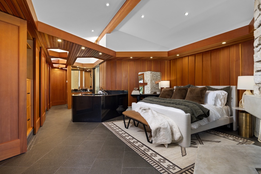 Unwind in your luxurious bedroom suite featuring rich wood finishes, a cozy fireplace, and elegant modern amenities for the perfect retreat.