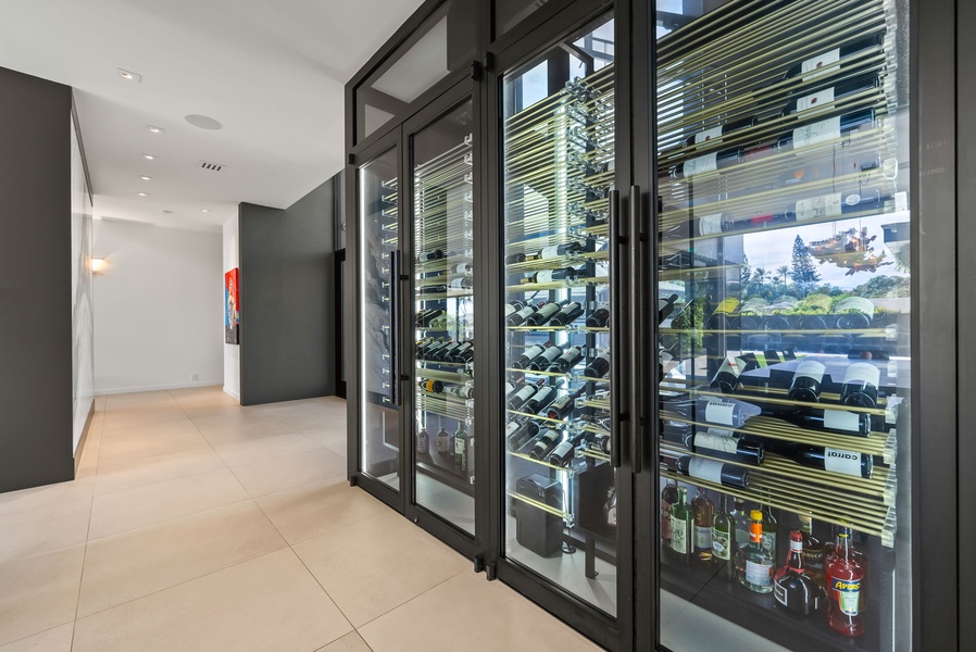 Glass-paneled wine display turns every vintage into art—an elevated backdrop for your island stay.