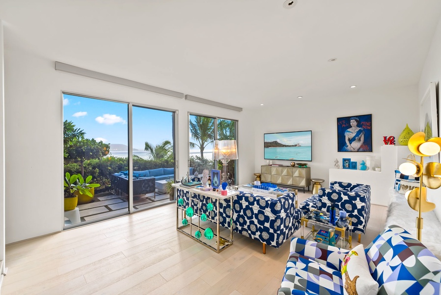Colorful downstairs living space with ocean-view sliders and bold décor.