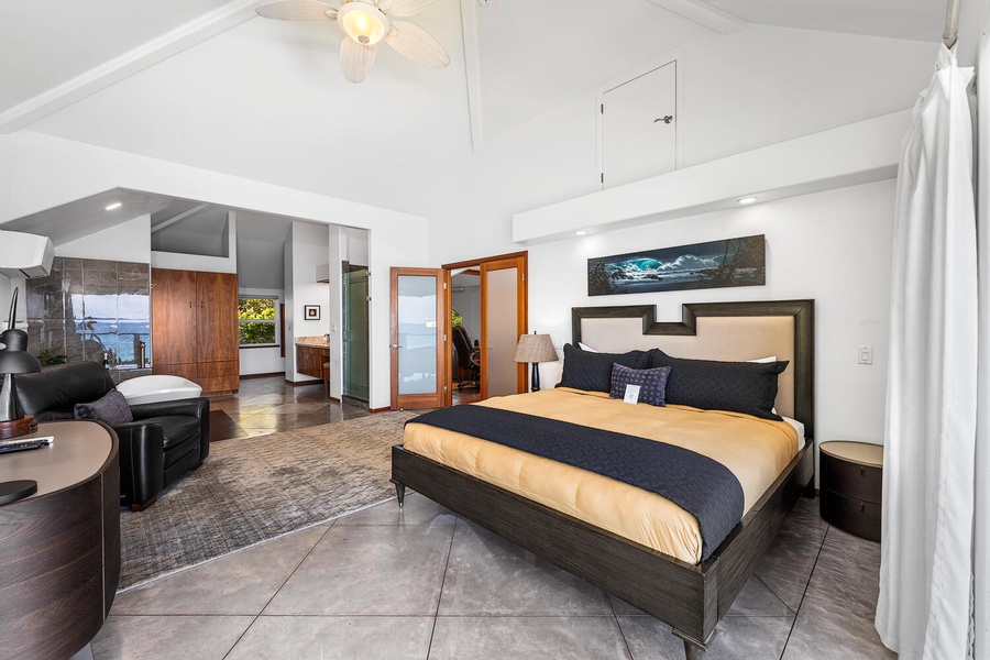 Spacious primary bedroom with vaulted ceilings, island-inspired decor, and ensuite bath.