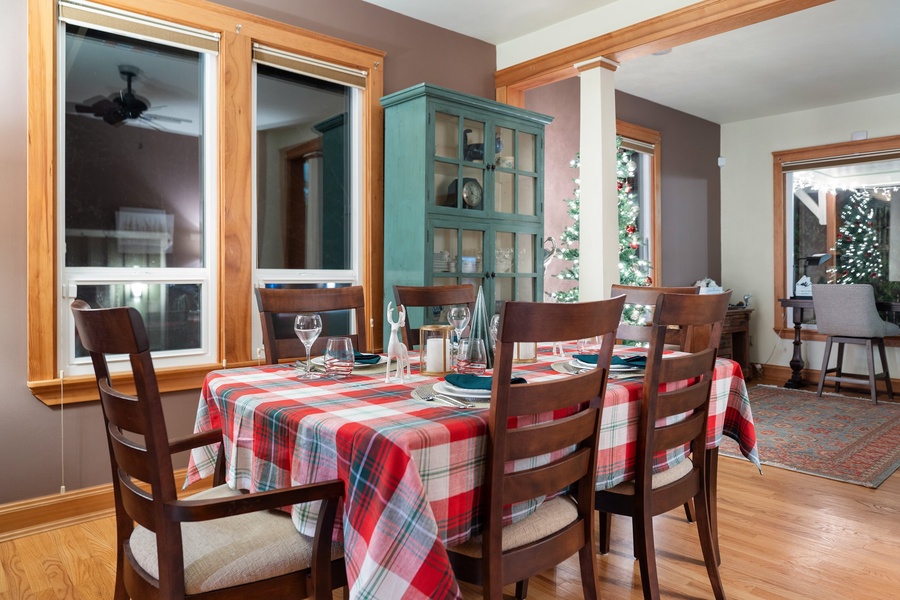 Inviting dining area framed by large windows and accented with holiday cheer.