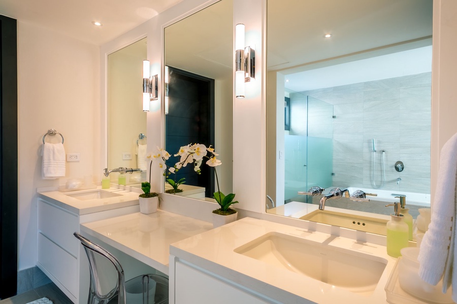 Modern ensuite bathroom featuring double sink and sleek lighting fixtures.