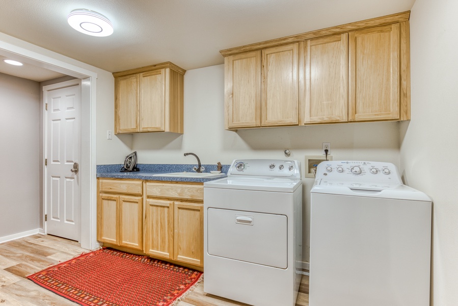 In unit washer and dryer with wooden cabinets for extra storage.