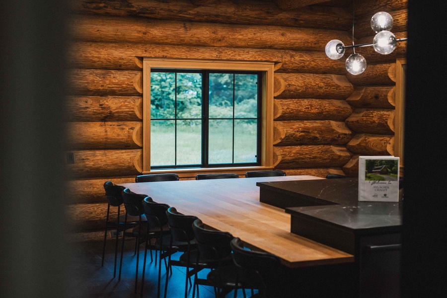 Share meals and conversation around the live-edge dining table with forest views nearby.