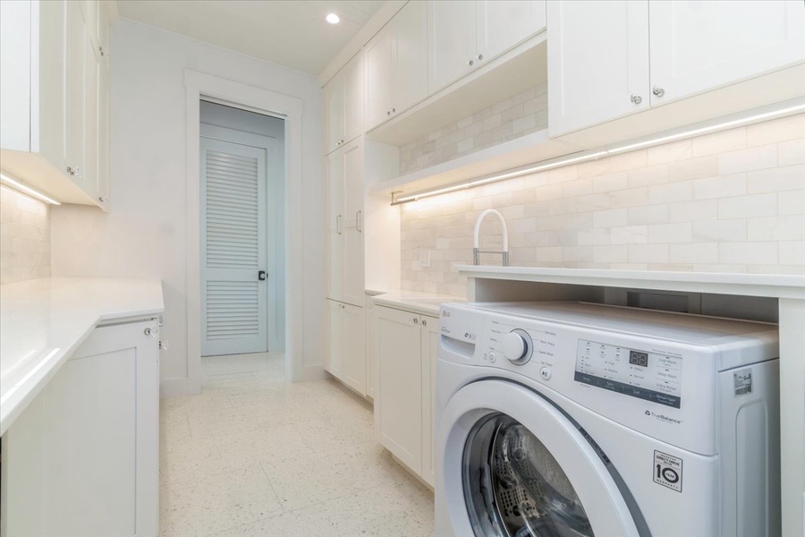 Dedicated laundry room with washer, dryer, and generous built-in storage.