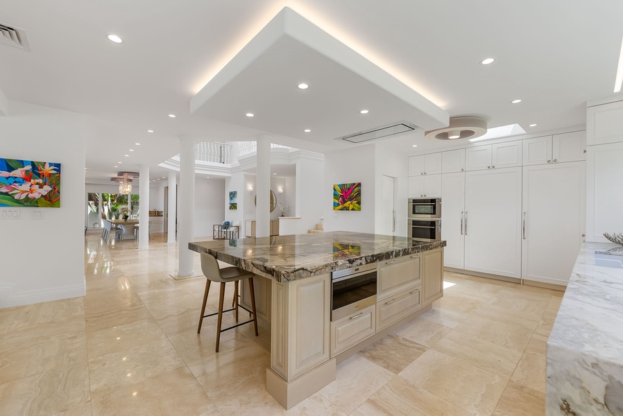 Sleek, modern kitchen with high-end appliances and open shelving—perfect for preparing island feasts.