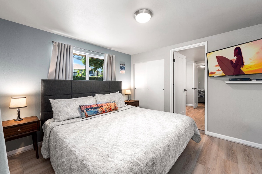 Spacious primary bedroom with king bed, modern décor, and natural light.