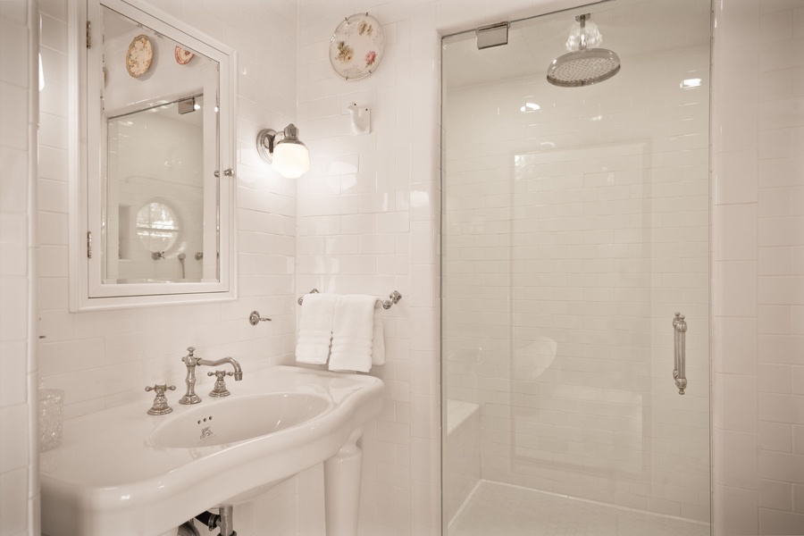 Refresh in your pristine bathroom with vintage charm—classic fixtures, rainfall shower, and fluffy towels await your relaxing retreat.