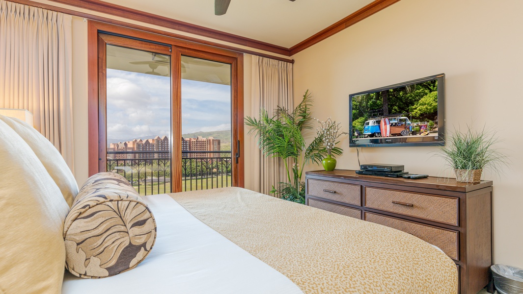 The primary guest bedroom featuring a TV, dresser and views.