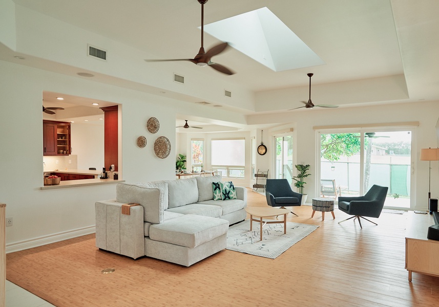 Relax in your spacious living room with vaulted ceilings, skylight, and cozy seating that opens to the kitchen.