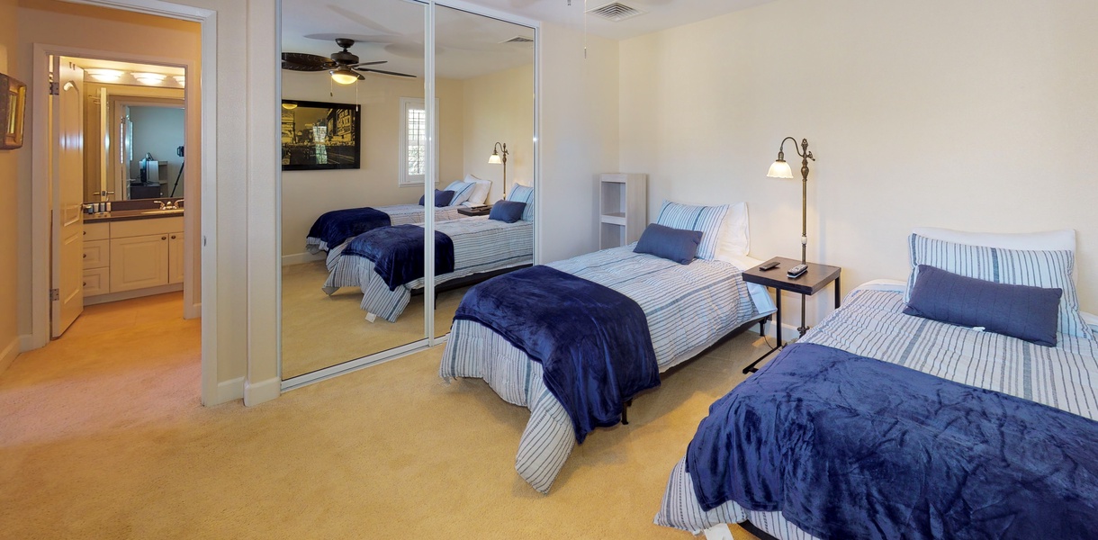 The third guest bedroom with large mirrors and soft linens.