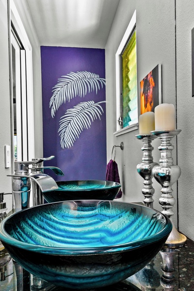 Vibrant and chic powder room boasting a striking blue vessel sink