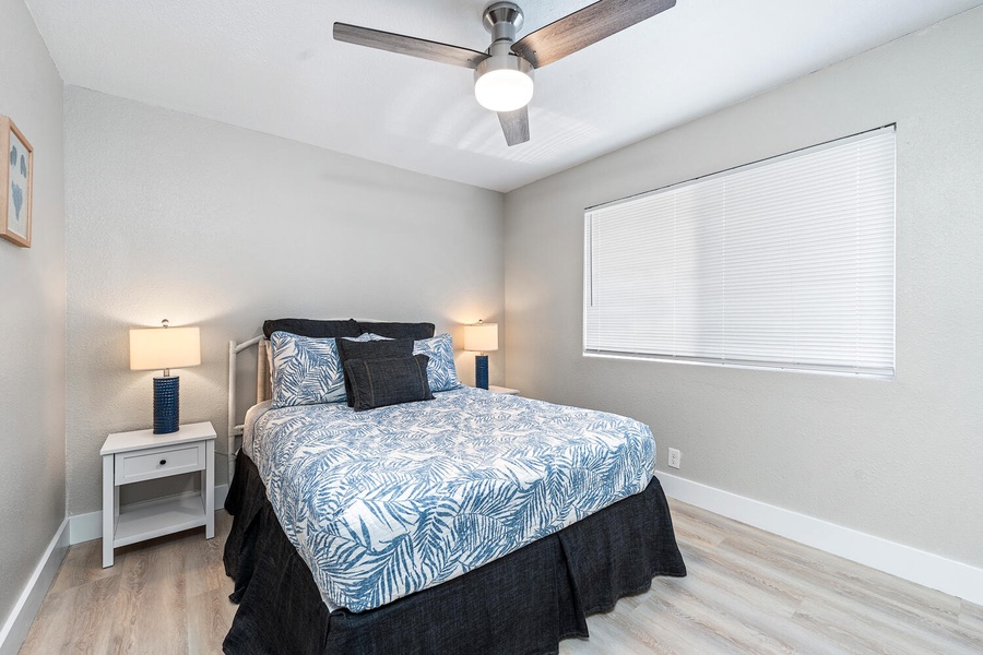Bright upstairs guest bedroom #2 with tropical bedding and a ceiling fan.