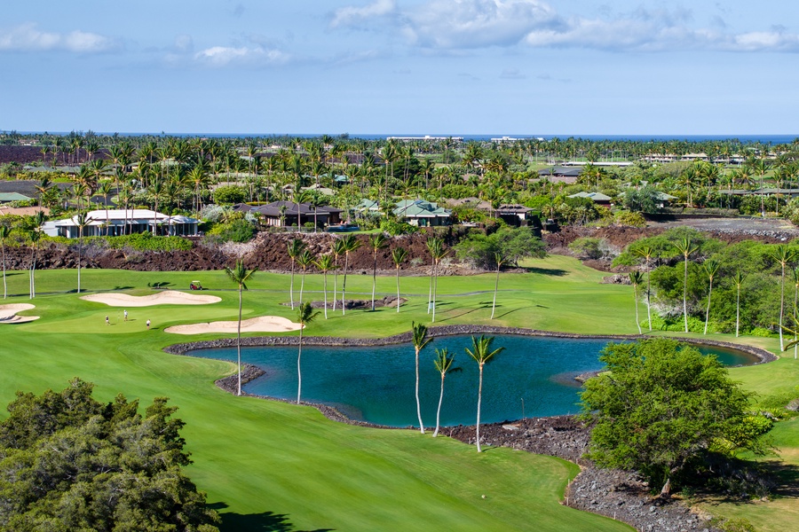 Scenic view of a lush golf course with a tranquil pond, surrounded by tropical greenery