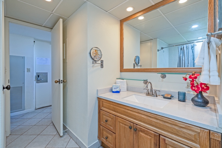 The bathroom features a stylish vanity with ample storage, framed wall art, and modern fixtures to create a clean and comfortable space.