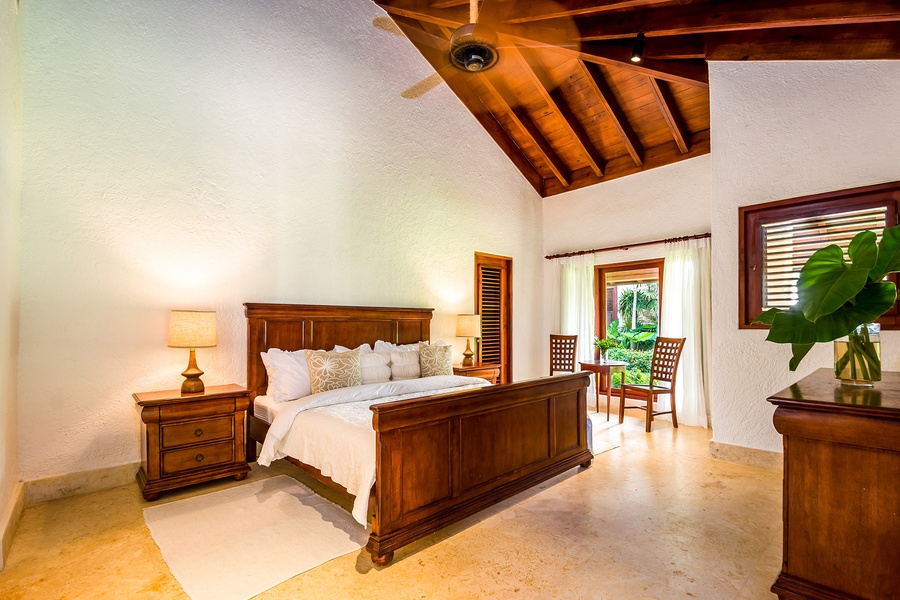 Elegant guest bedroom with wooden furniture and garden view.