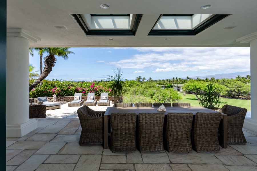 Outdoor dining area with wicker seating and beautiful views of the landscape.