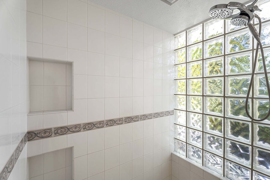 Primary walk in shower with glass block for natural light