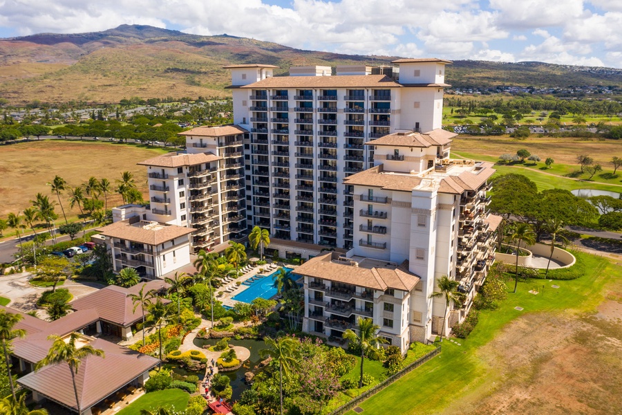 Resort complex surrounded by lush golf course and tropical mountains in Hawaii's scenic landscape.