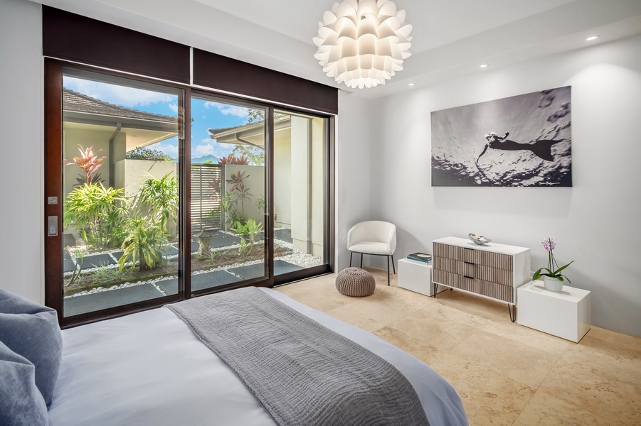 Serene bedroom with large sliding doors opening to lush garden views, creating a peaceful ambiance.