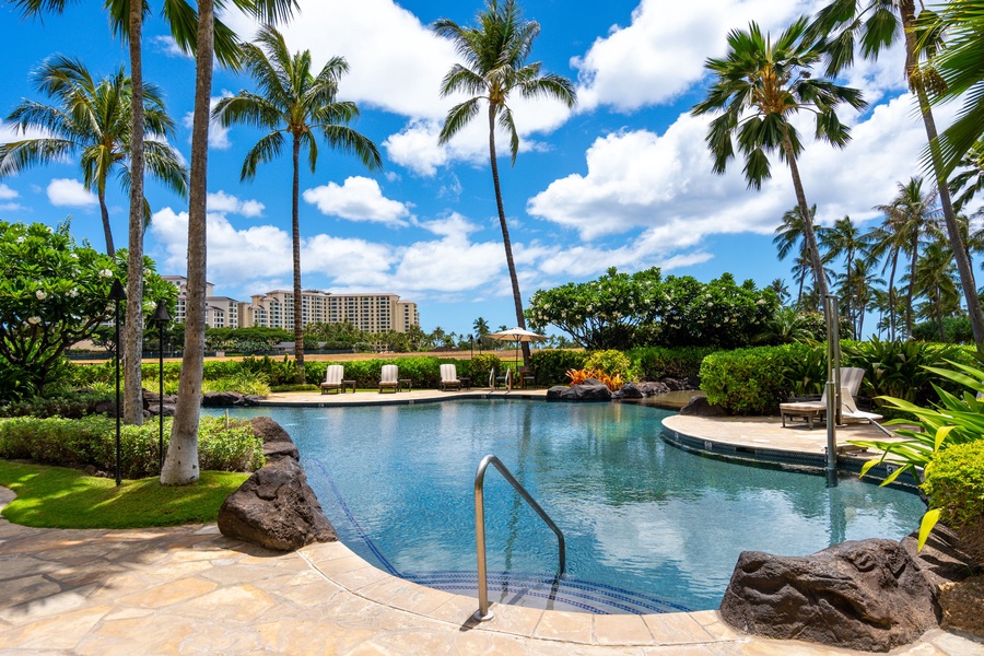 Tropical resort-style pool surrounded by swaying palms and lush landscaping creates your perfect Hawaiian paradise retreat.