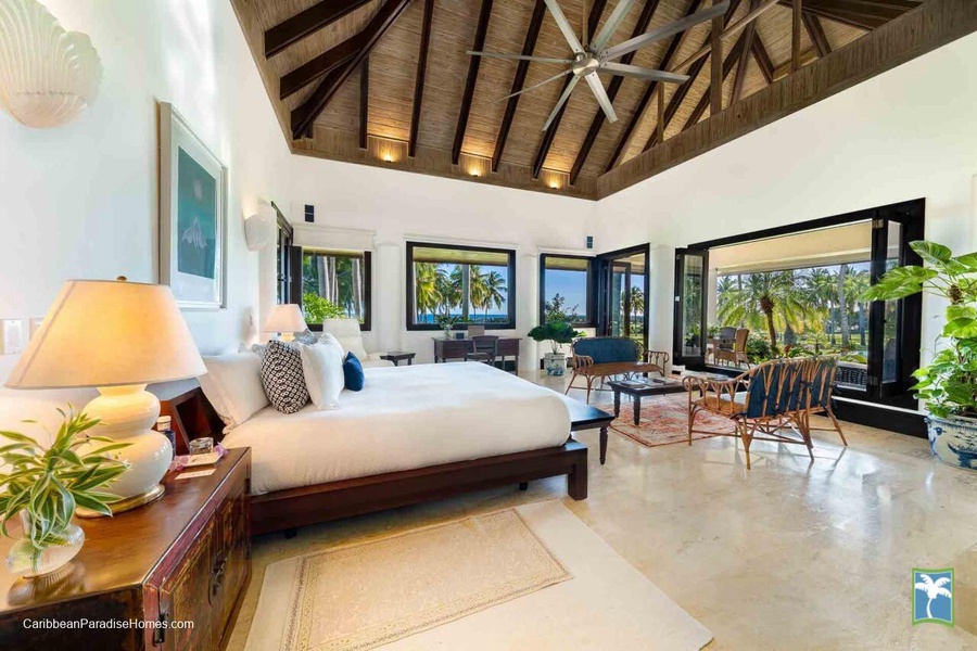 Wake up to stunning views in this beautifully appointed primary bedroom with direct access to the lush outdoors.