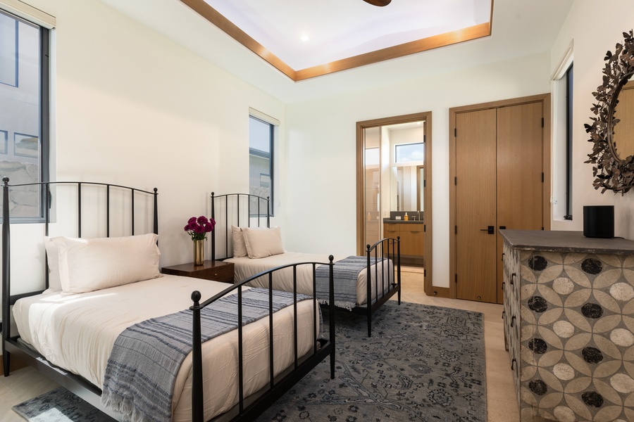The fourth guest bedroom downstairs has two twin-sized beds, dresser, and ensuite bathroom. The twin-sized beds can be converted to a king.