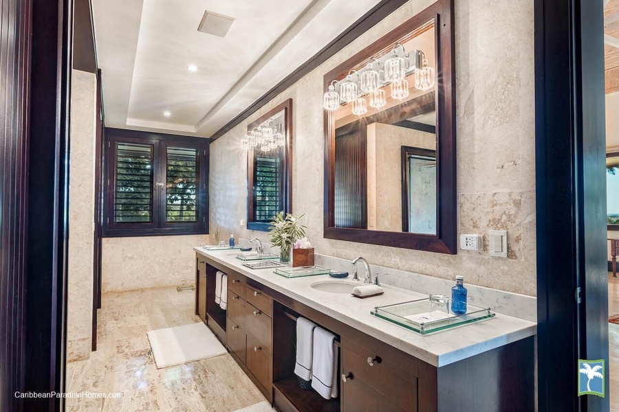 The primary ensuite bathroom with double sinks and elegant mirrors.