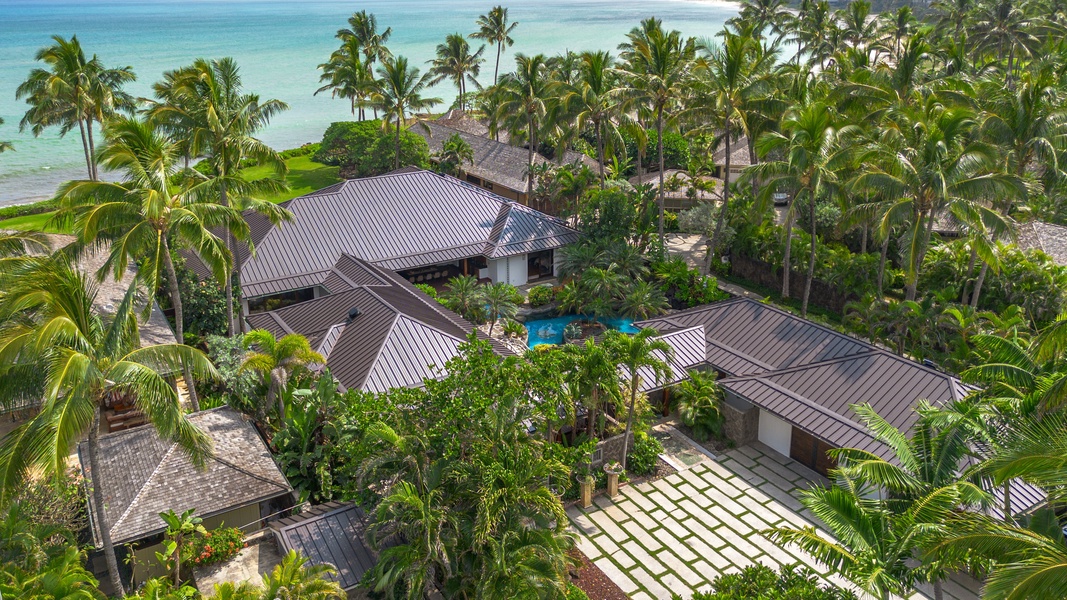 Top‑down view of the estate tucked into lush tropical gardens beside the Pacific.