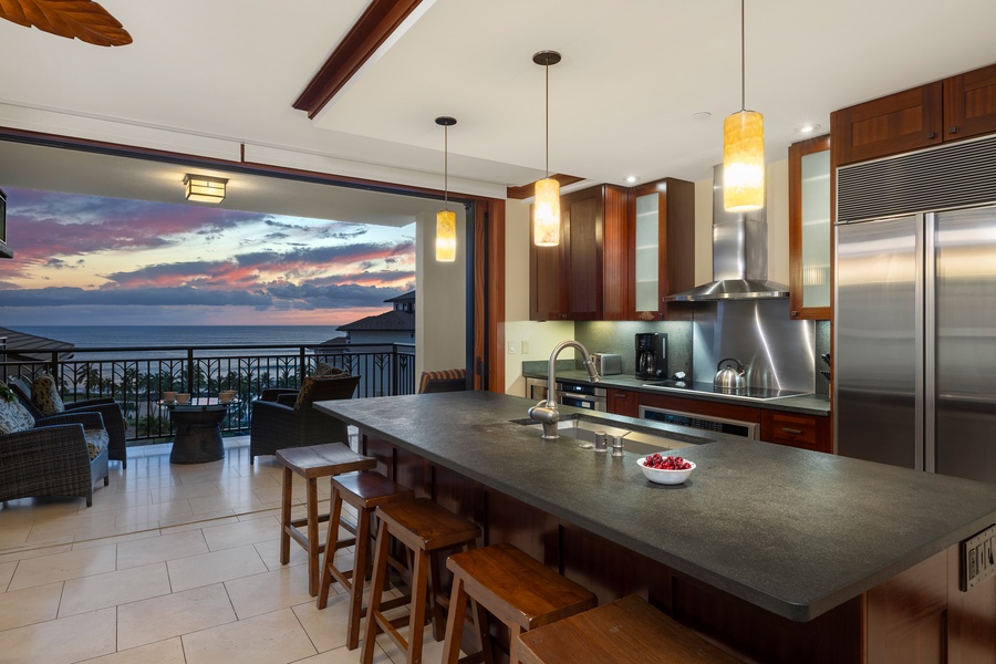 An open kitchen with stainless steel appliances and bar seating.