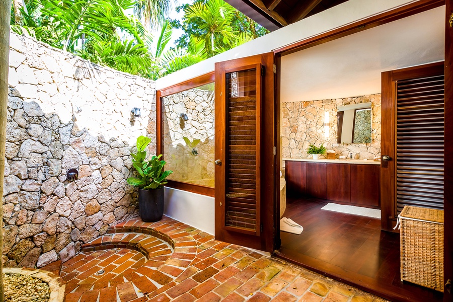 Ensuite bathroom with an outdoor feel and stone walls.