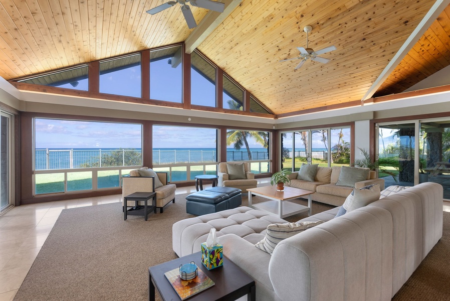 Bright and airy seating area framed by floor-to-ceiling windows and serene ocean scenery.