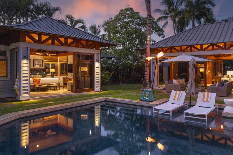 A view from the primary bedroom spans the pool to the third guest suite, along with the furnished lanai outside the dining and living rooms